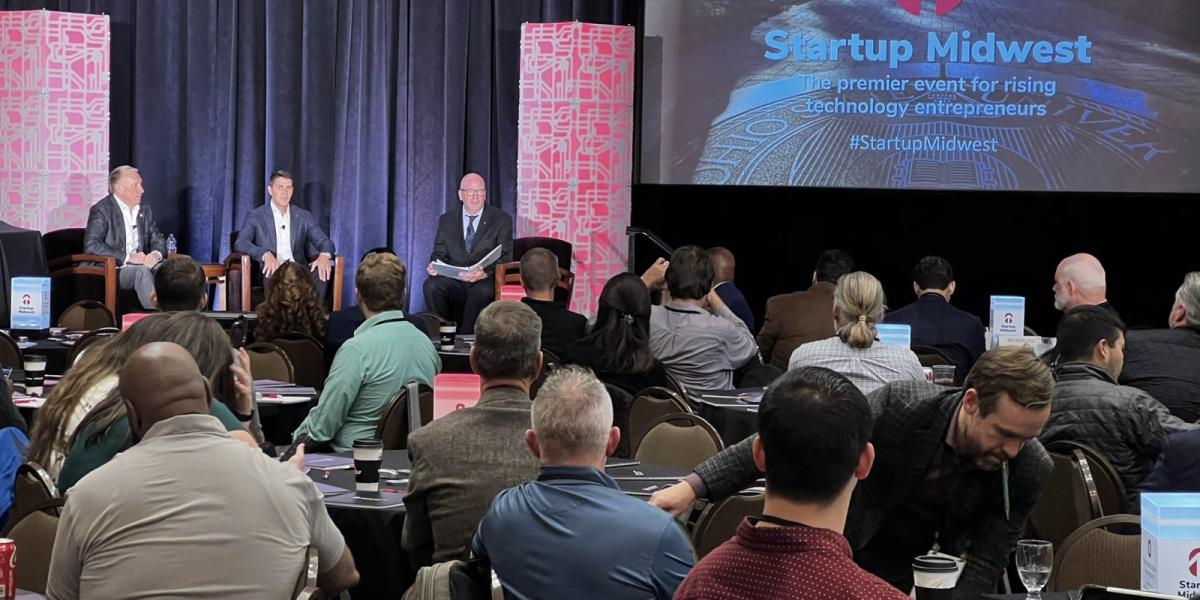 Software entrepreneur Ratmir Timashev, Workday co-CEO Carl Eschenbach and Ohio State's Acting President Peter Mohler on stage together in front of an audience at Startup Midwest